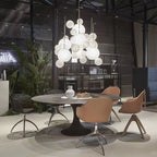 Clérachic Bubble Cluster Pendant Lights clustered together over a round dining table in an industrial-style loft.