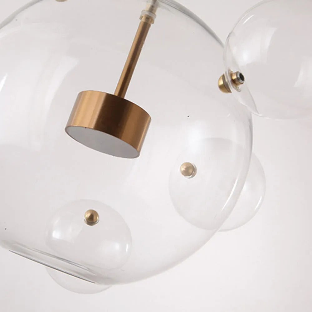 Close-up of the Clérachic Bubble Cluster Pendant Light's brushed-brass LED module and the ball fittings joining its glass bubbles.