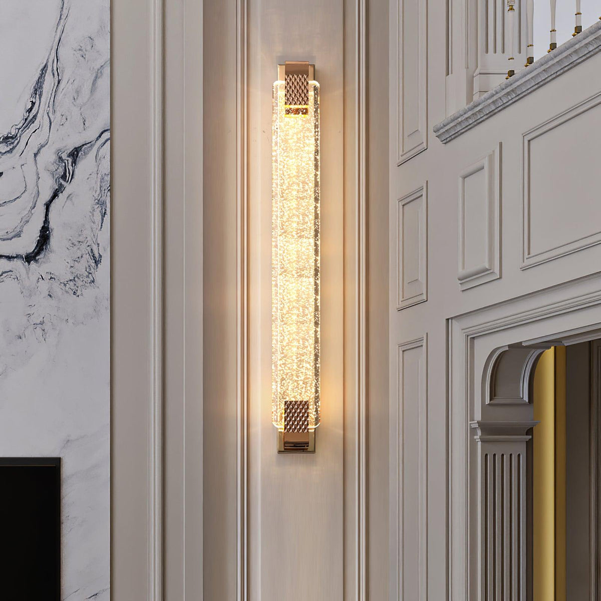 Tall narrow Clérachic wall light glowing in a hallway with white wall panelling, a marble wall and an arched opening.