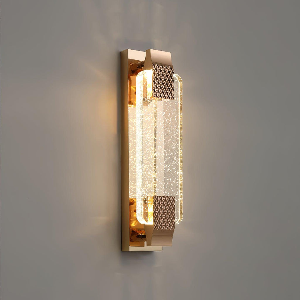 Three-quarter view of the rose gold backplate and bubble crystal of this Clérachic wall light, lit against a grey wall.