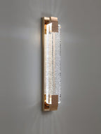 Vertical Clérachic bubble-crystal wall light lit on a grey wall, light spreading up and down from the gold ends.