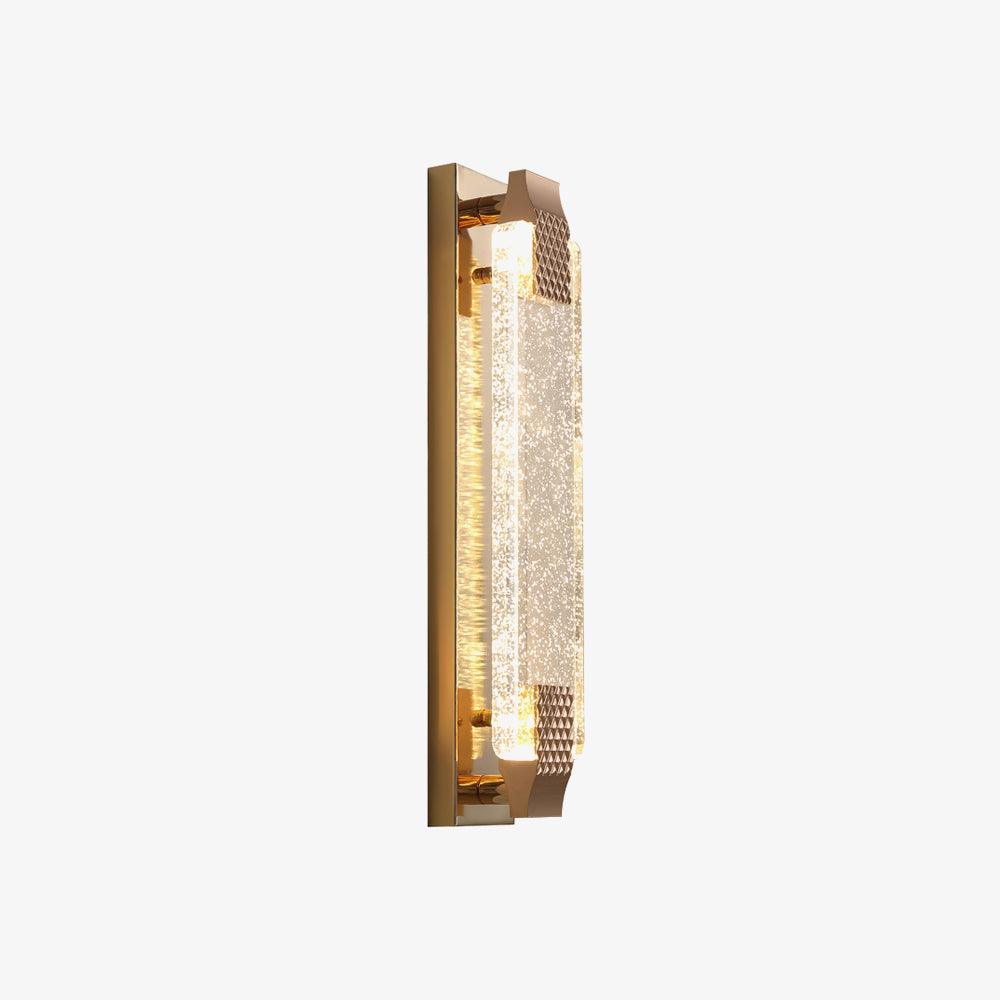 Slim gold-backed crystal wall light at an angle on a white background, its textured caps catching the light, from Clérachic.