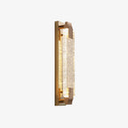 Slim gold-backed crystal wall light at an angle on a white background, its textured caps catching the light, from Clérachic.