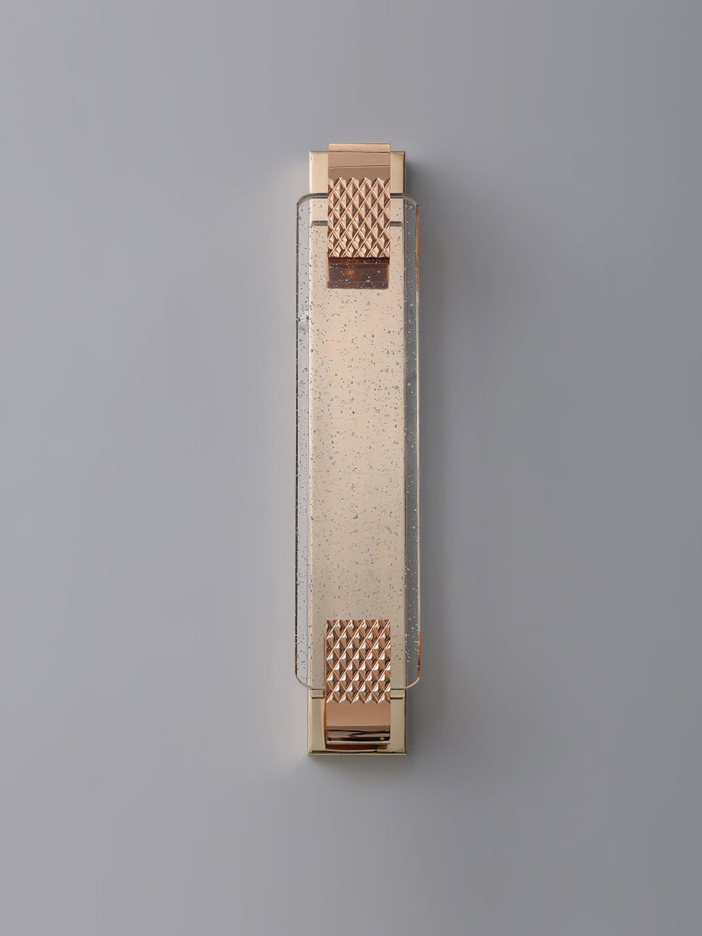 Unlit rose gold wall light from Clérachic on a pale grey wall, its crystal bar flecked with tiny bubbles.