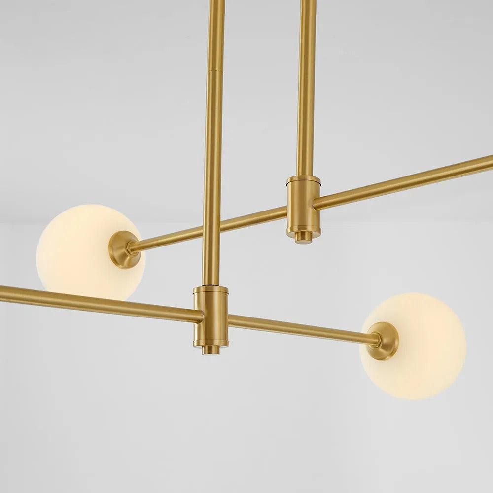 Close-up of the Clérachic pendant's crossing bars, showing the suspension cables and opal globes at each arm's end.