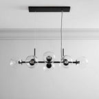 Black Clérachic bubble glass linear pendant light with eight staggered clear globes, mounted on a white ceiling with crown molding.