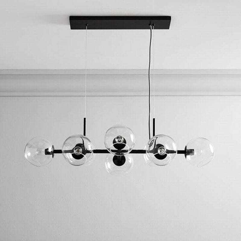 Black Clérachic bubble glass linear pendant light with eight staggered clear globes, mounted on a white ceiling with crown molding.