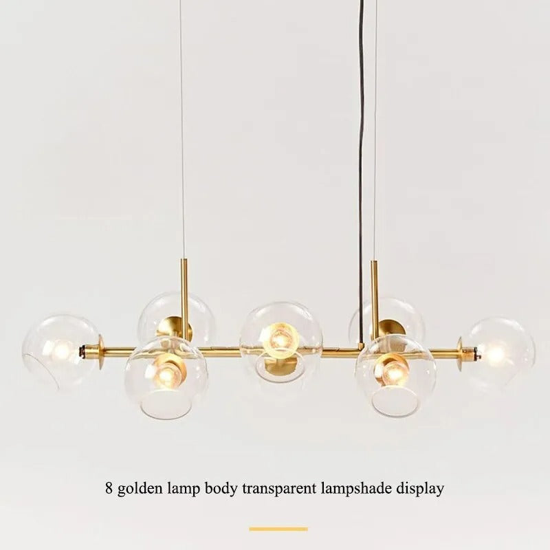 Studio display of the gold-body Clérachic bubble glass pendant with all eight clear glass globes lit.