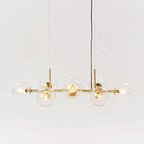 Gold-body Clérachic bubble glass pendant with clear glass globes, photographed straight-on against white.
