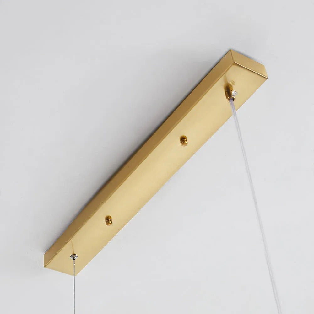 Close-up of the gold rectangular ceiling canopy on the Clérachic bubble glass linear pendant, showing its two cable posts.