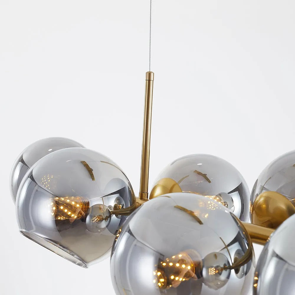 Close-up of a filament bulb glowing inside a smoke gray glass globe on the black Clérachic bubble glass pendant.