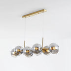 Gold-body Clérachic bubble glass pendant with smoke gray globes, angled to show the full ceiling canopy and cables.