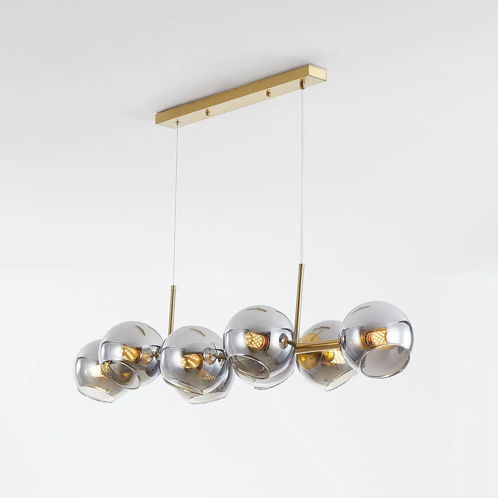 Gold-body Clérachic bubble glass pendant with smoke gray globes, angled to show the full ceiling canopy and cables.