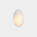 Clérachic Bubble Glass Wall Sconce in white, the tall egg Model A lit low so a soft warm core spreads through the frosted glass.