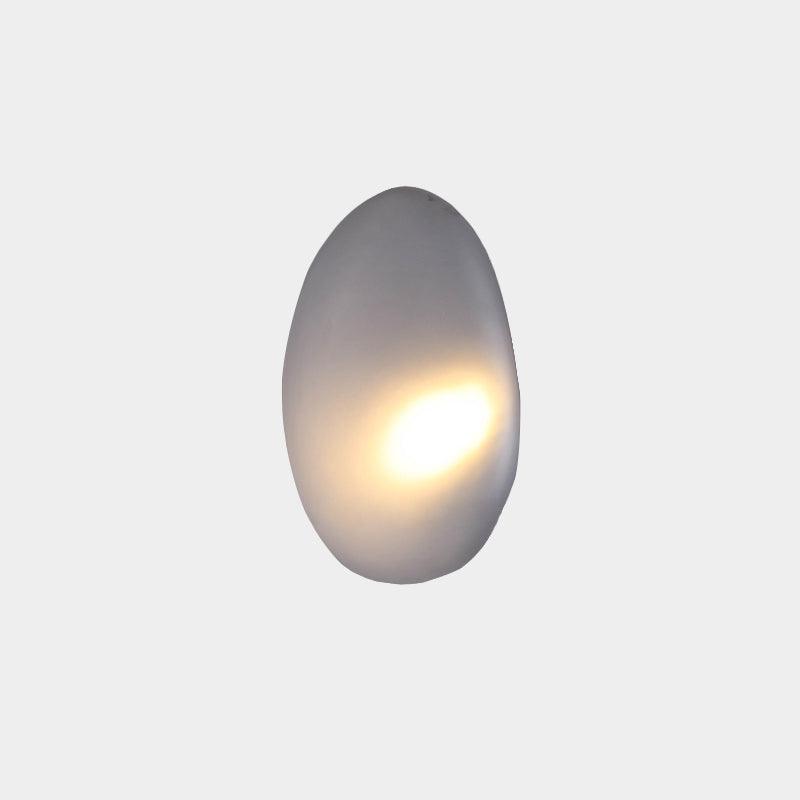 Smoky gray Clérachic Bubble Glass Wall Sconce, tall egg shape, lit with a warm teardrop of light glowing right of centre.
