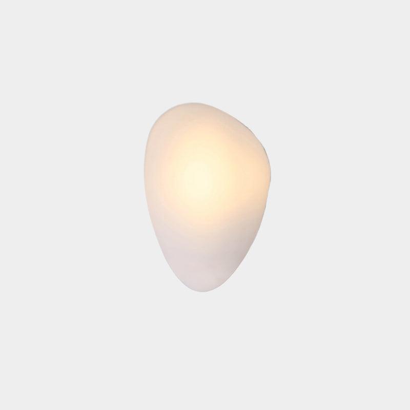 Clérachic Bubble Glass Wall Sconce in white, the rounded pebble Model C, glowing warm near the top of the flush-mounted shade.