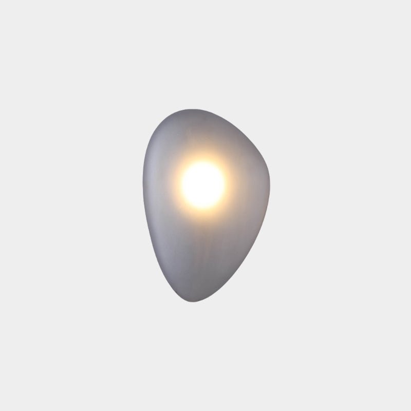 Smoky gray Clérachic Bubble Glass Wall Sconce with a rounded pebble profile, lit by a crisp warm hotspot high in the grey glass.
