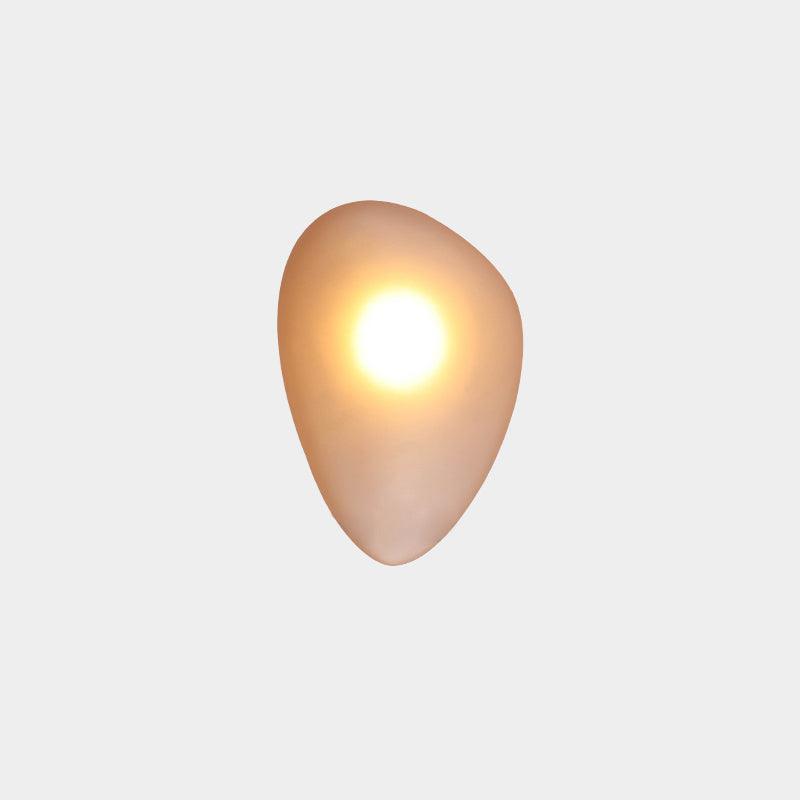 Clérachic Bubble Glass Wall Sconce in amber, rounded pebble shape, lit with one bright warm point high in the honey-gold glass.