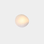 White Clérachic Bubble Glass Wall Sconce in the squat round shape, its warm light diffusing evenly across the creamy frosted glass.