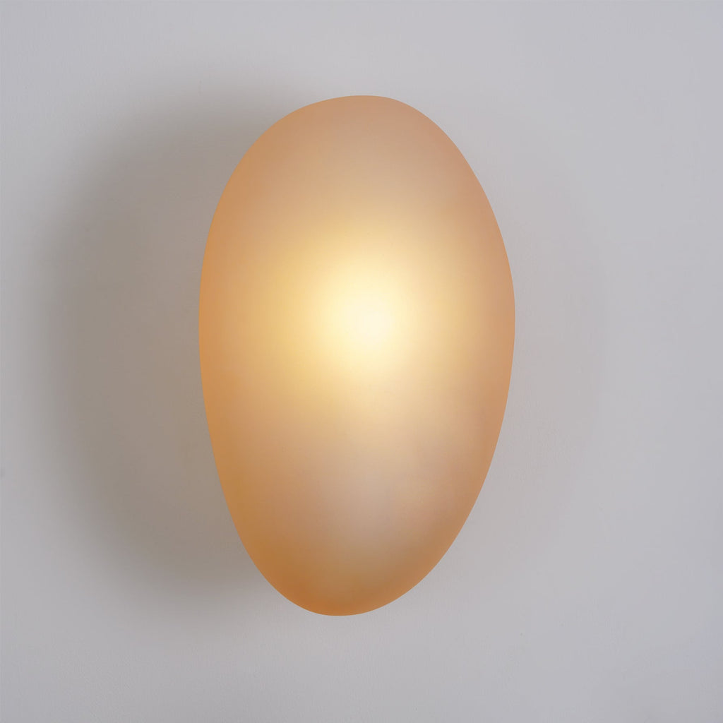 Clérachic Bubble Glass Wall Sconce in amber mounted flush to a plain painted wall, casting a soft shadow with no visible arm or stem.