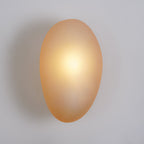 Clérachic Bubble Glass Wall Sconce in amber mounted flush to a plain painted wall, casting a soft shadow with no visible arm or stem.
