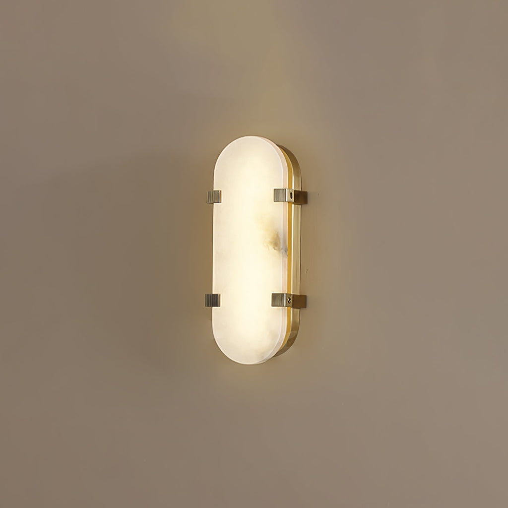 Clérachic Calla wall light lit on a taupe wall, oval alabaster panel held by two brass straps.