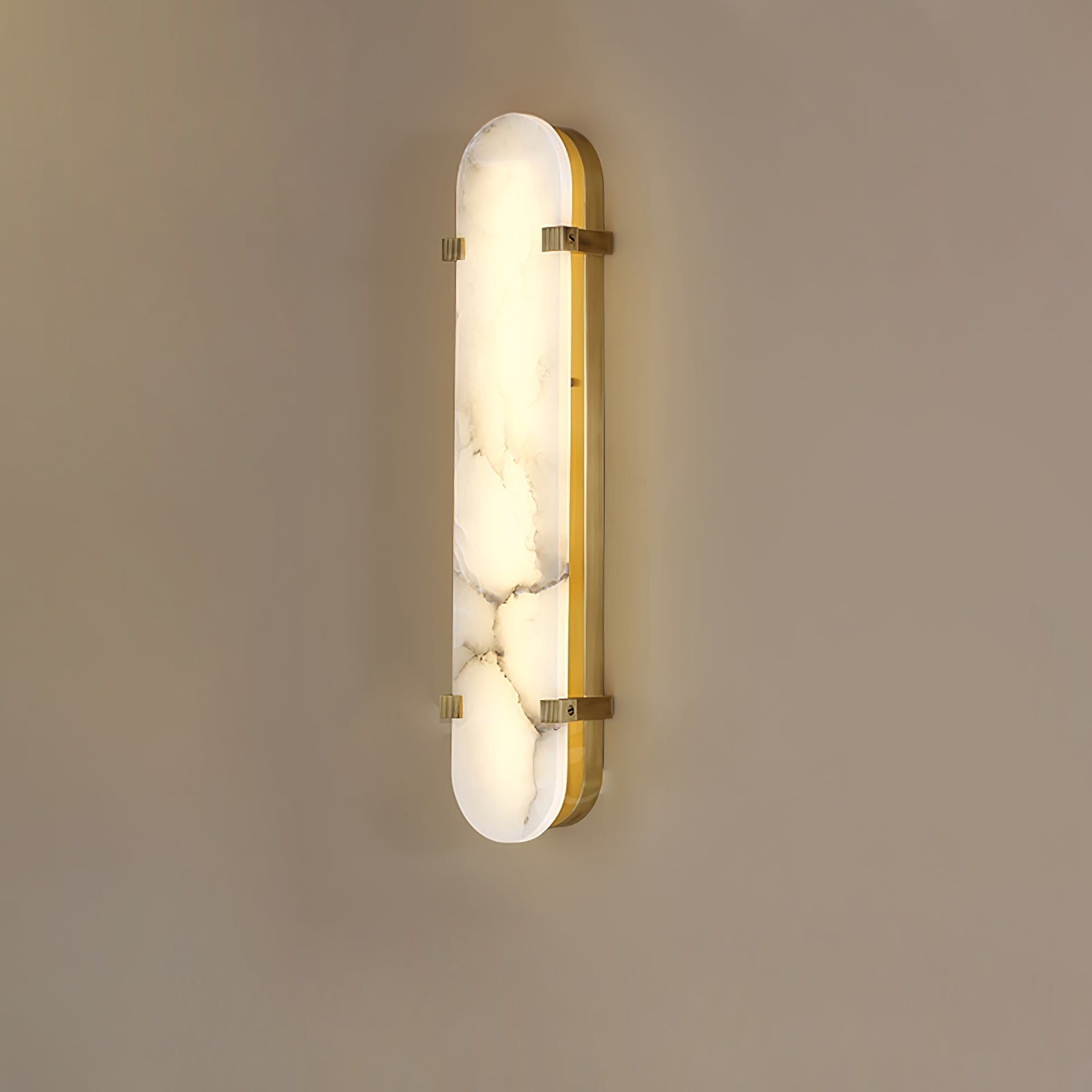 Clérachic Calla wall light in the taller size, brass straps crossing veined alabaster.