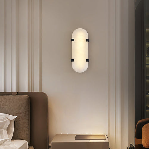 Clérachic Calla wall light lit above a sofa in a panelled room with tall windows.