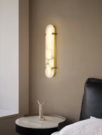 The Clérachic Calla wall light above a black armchair and round marble side table.