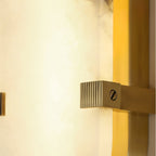 Close view of the Clérachic Calla brass channel with light spilling along the stone edge.
