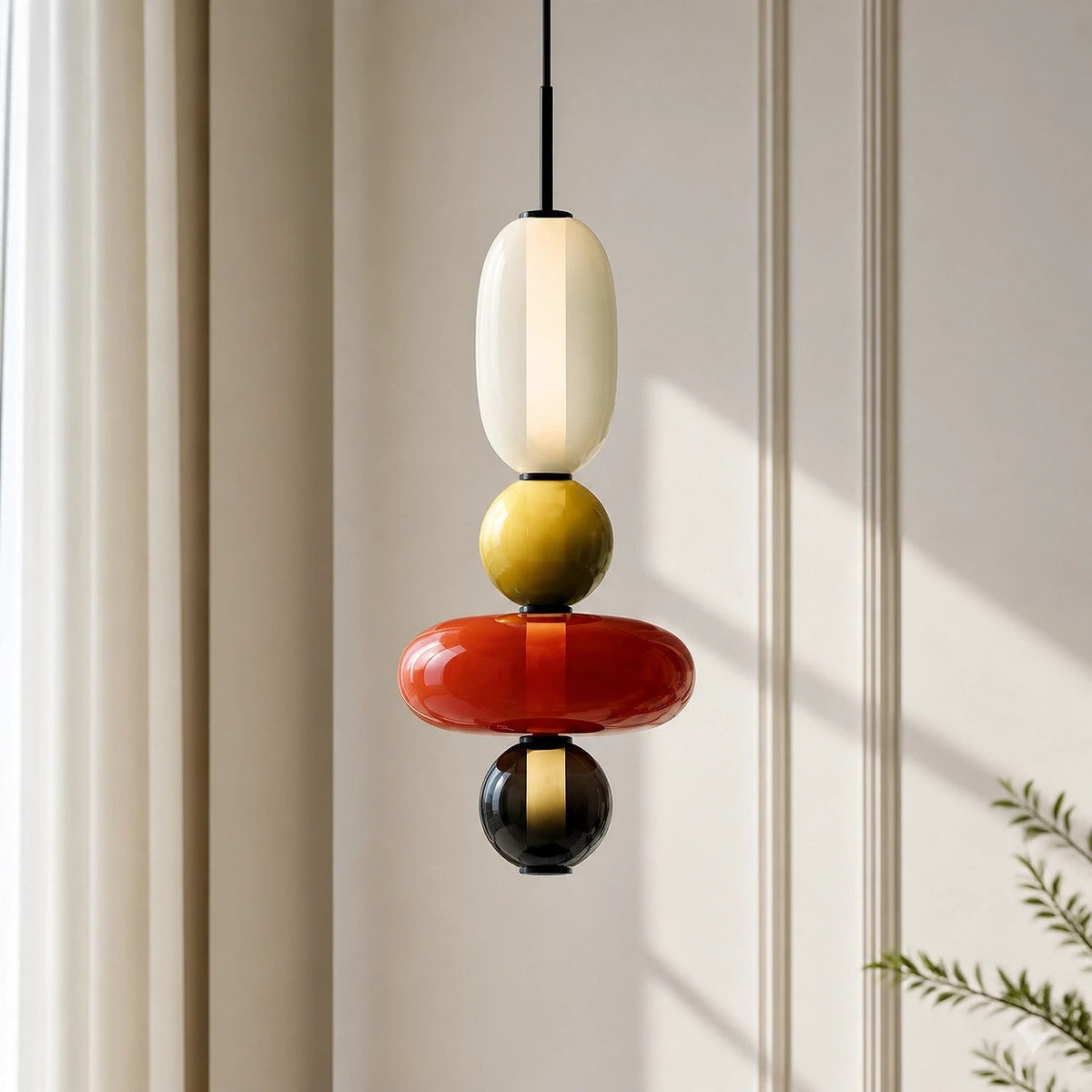 Detail of a Clérachic pendant with an opal capsule, olive ball, wide red disc and a small black ball on a black cord.