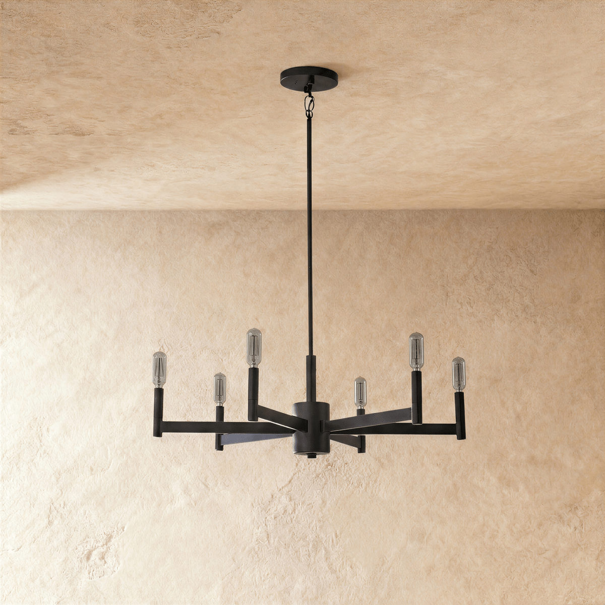 Clérachic six-arm black chandelier shown with the bulbs switched off, clear tubular lamps on square tubes, beneath a plaster ceiling.