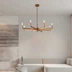 Clérachic eight-arm gold chandelier above a pale sofa in a calm living room with a brushed abstract panel at the left.