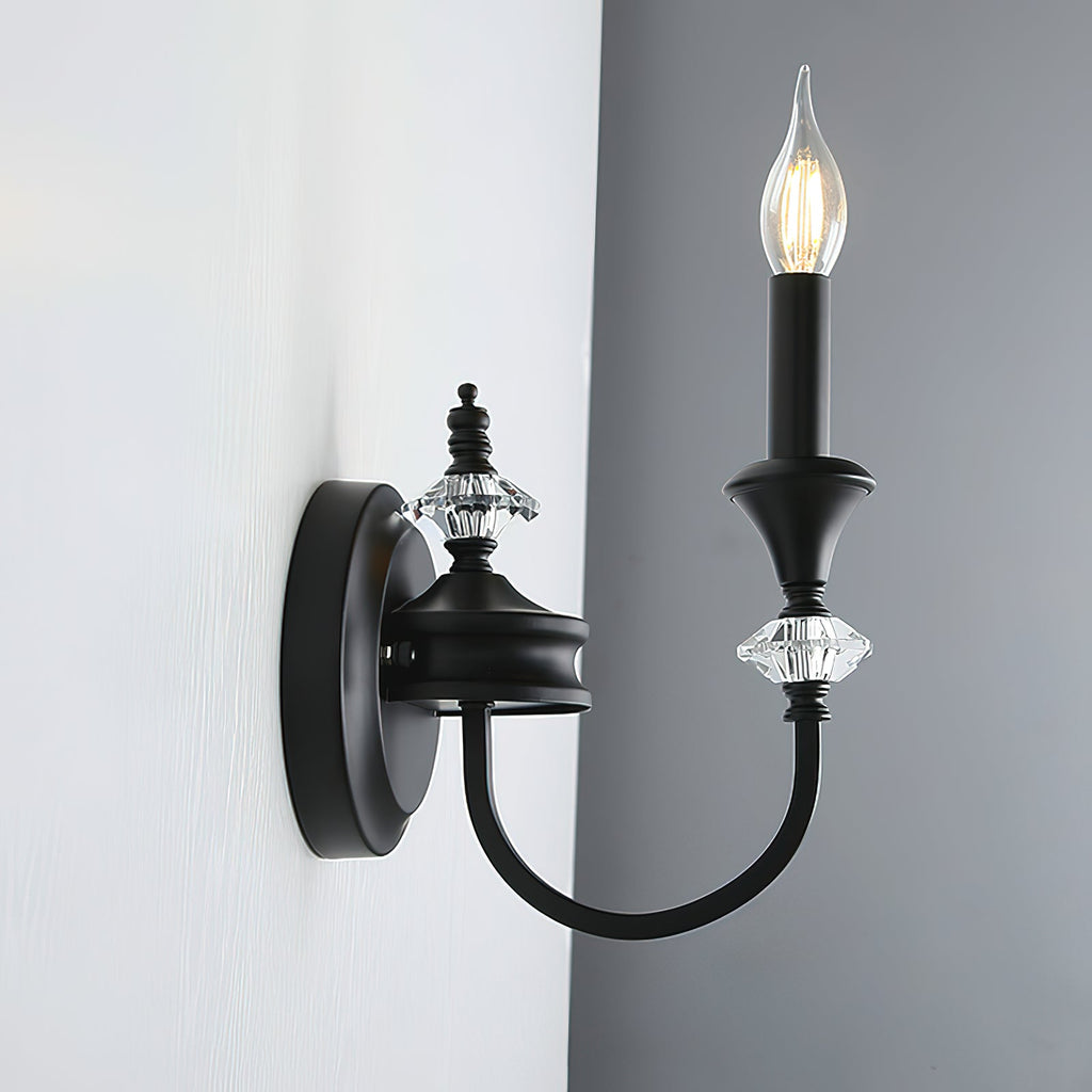 Side view of a black single-arm Clérachic wall light on a grey wall, its curved iron arm reaching out from a round backplate.