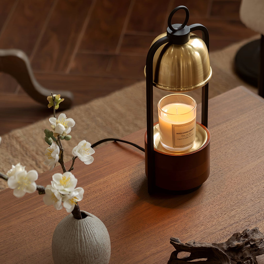 This Clérachic candle warmer lamp stands on a walnut table beside a small vase of white blossom, the candle softly lit beneath its dome.