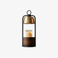 Clérachic candle warmer lamp with a gold dome and black loop handle above a walnut base, shown on a light backdrop.