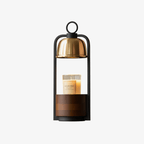 Front view of the Clérachic candle warmer lamp on white, with its black frame, gold dome and walnut-banded base.
