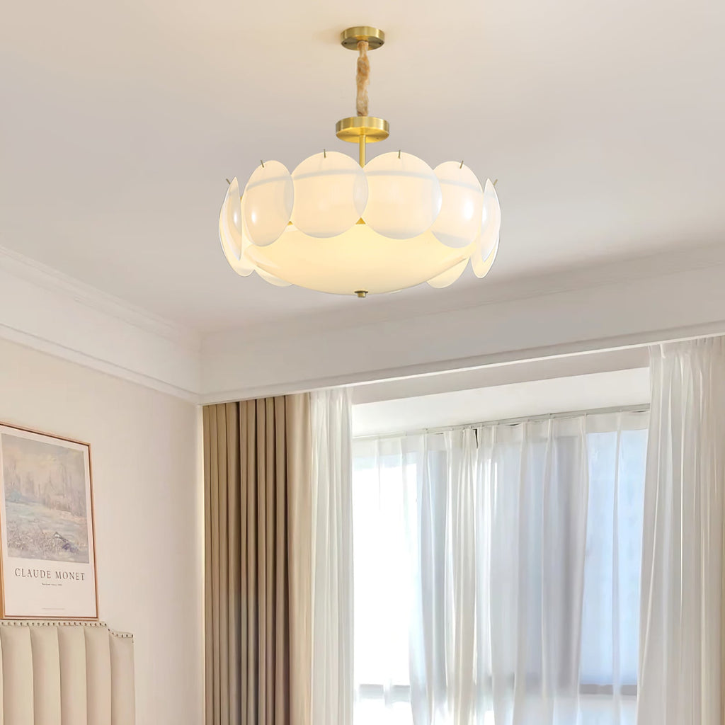 Clérachic chandelier with layered white shell shades hanging on a short chain in a bright room with sheer curtains and a framed print.