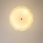 View from directly below of this Clérachic chandelier lit, a warm glow behind the scalloped ring of white shell shades.