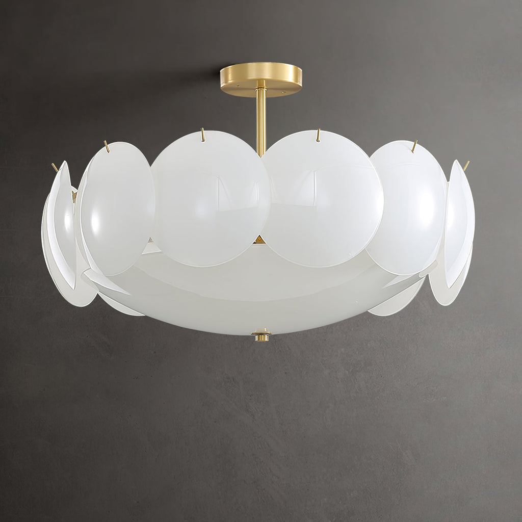 Semi-flush Clérachic chandelier with a plain brass stem and overlapping frosted white shades, hung against a dark grey wall.