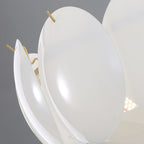 Close view of two curved shell shades held by slim brass pins on this Clérachic chandelier, with a soft light behind.
