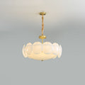 Clérachic chandelier on a twisted chain below a pale ceiling, lit, with a ring of round white shades around a glowing centre.