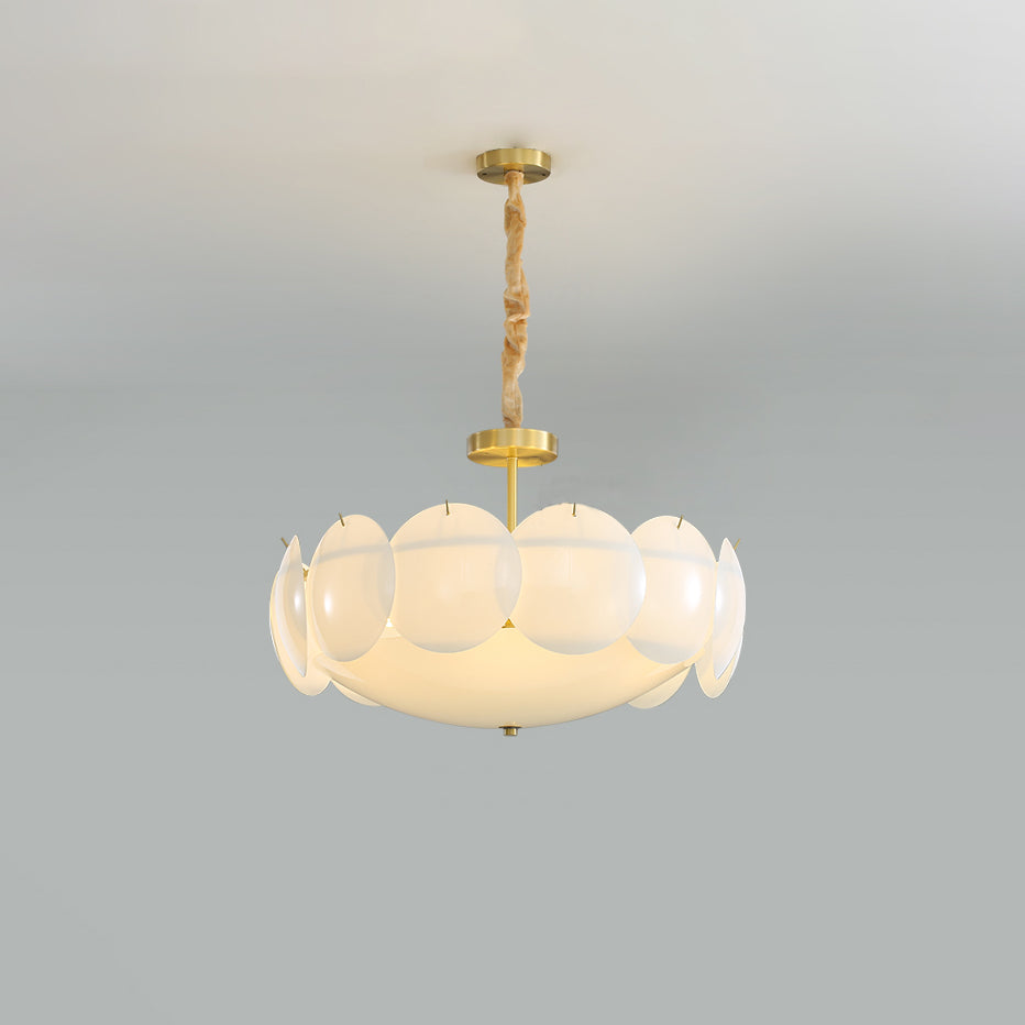 Clérachic chandelier on a twisted chain below a pale ceiling, lit, with a ring of round white shades around a glowing centre.