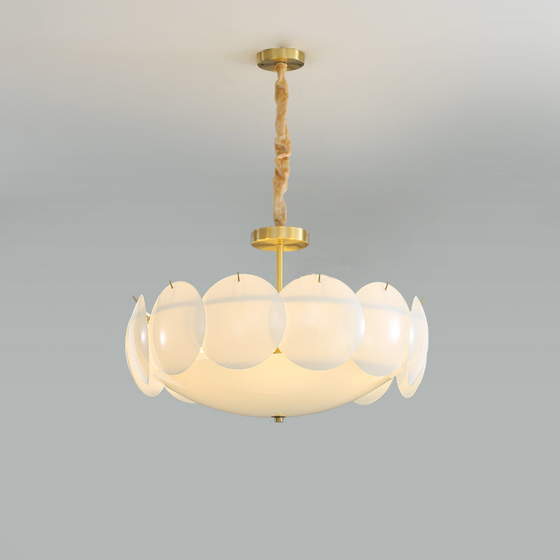 Straight-on view of the lit Clérachic chandelier, brass stem and chain above overlapping white shades, on a soft grey backdrop.