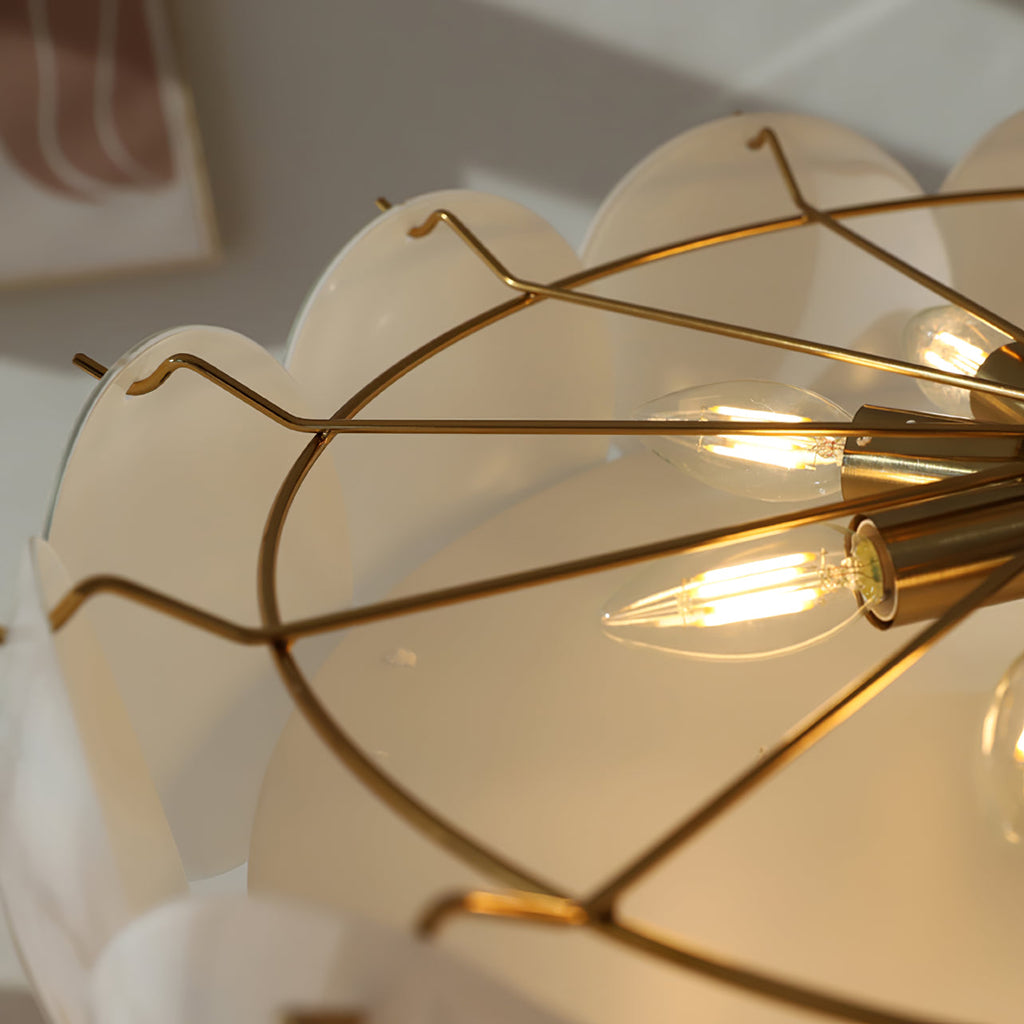 Close view into the open frame of this Clérachic chandelier, showing slim brass arms and filament candle bulbs inside the shades.