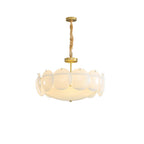 Smaller view of the lit Clérachic chandelier on a plain white background, with the twisted chain and brass canopy above.