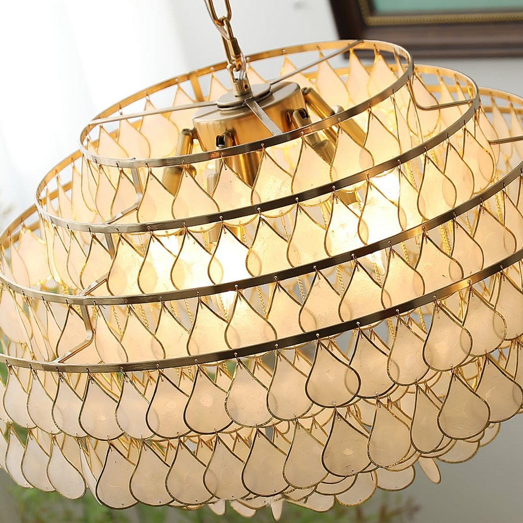 Looking up into this Clérachic chandelier, the gold rings, the top plate and the shell teardrops show glowing warm inside.