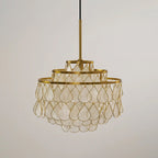 A small Clérachic chandelier on a gold rod and black cord, its three tiers of shell teardrops unlit against a grey backdrop.