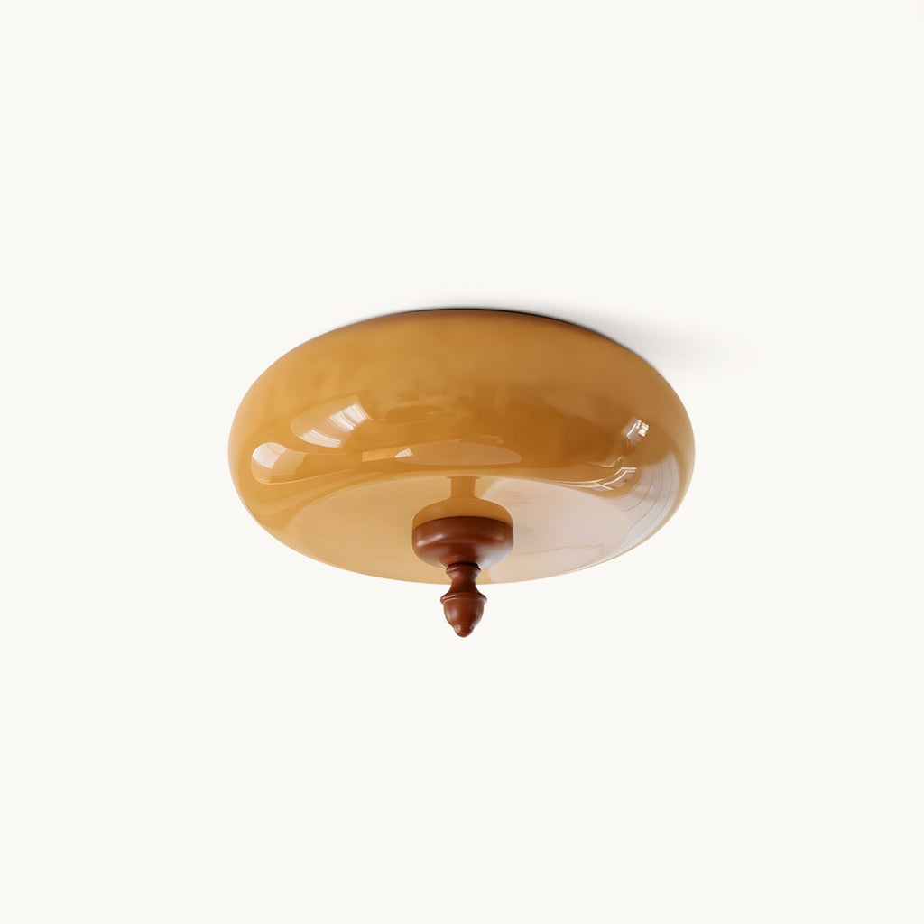 Caramel glass flush-mount ceiling light from Clérachic, a rounded amber shade with a walnut-toned finial, on a plain white background.