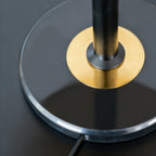 Close view of the brass ring where the black stem meets the round black base of this Clérachic lamp.